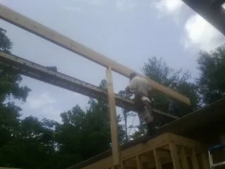 Carpenter setting a ridge beam over a new addition frame — Ice Dam Removal by Roofing Brothers in Chenango Forks