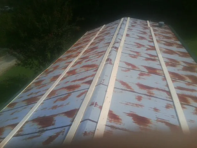 Rusted metal roof panels with new wood purlins before replacement — Storm Damage Roof Repair in Chenango Forks by Roofing Brothers