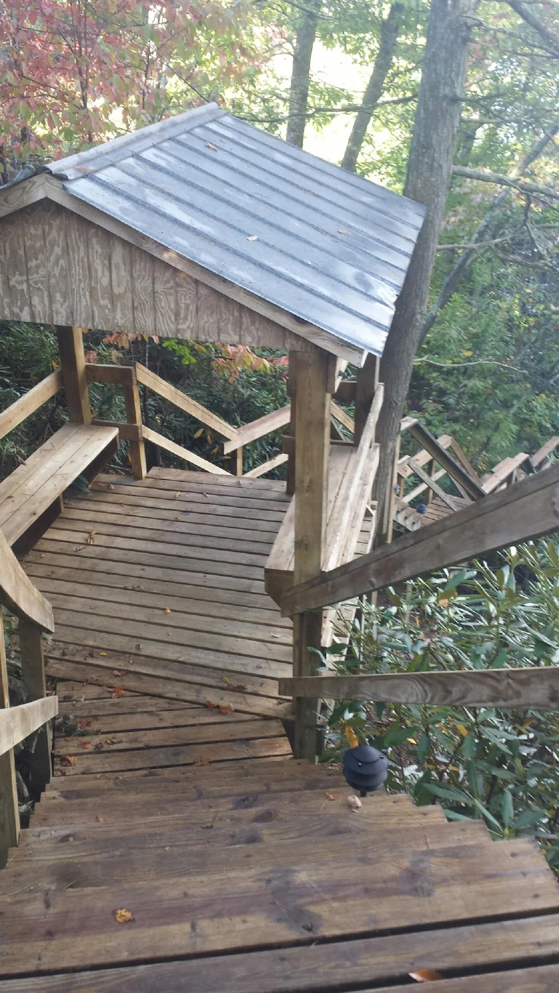 Metal roofed shelter over wooden steps on a wooded walkway — Skylight Repair & Installation work by our crew in Chenango Forks