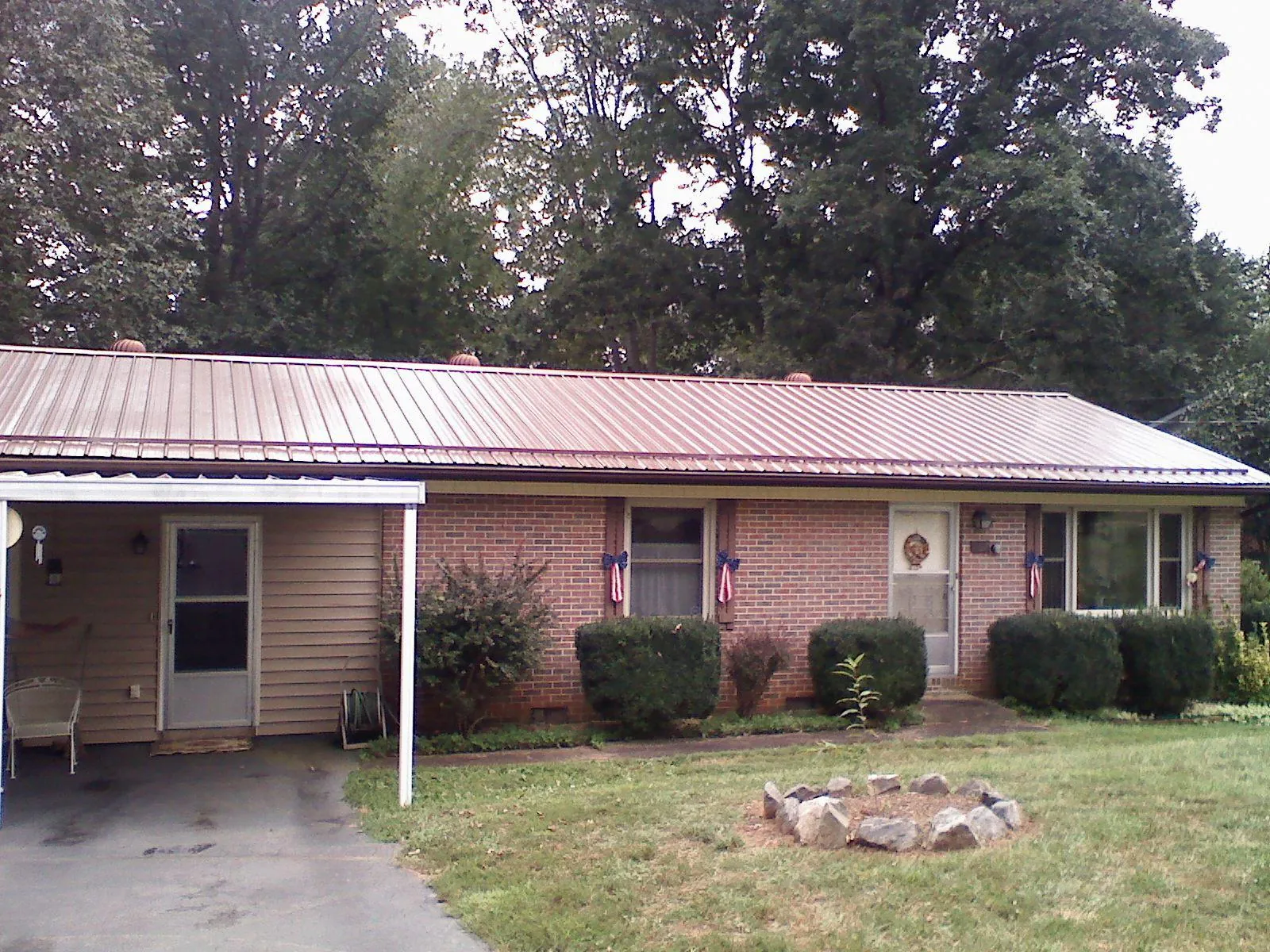 Bronze metal roof and carport on a brick ranch home — Roof Repair work by our crew in Chenango Forks